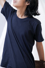 Clothing model. Young Asian man with long curly hair close up shot isolated on white. Asian young man wearing navy blue t-shirt isolated on white background. As if he were modeling a plain t-shirt.