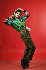 beautiful female model in striped green and black shirt and brown trousers