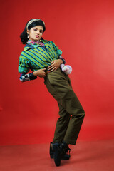 beautiful female model in striped green and black shirt and brown trousers