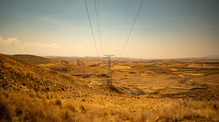
Light tower with yellow scenic landscape and mountains in the background, cloudy sky in the...