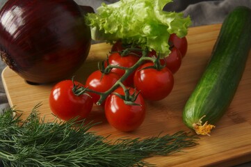tomato, cucumber, lettuce, dill on cutting board 