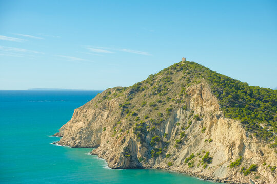 Panoramic view to Mediterranean sea and cliffs with watchtower Torre del Aguilo on a sunny day