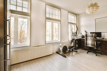 House with exercise cycle and computer on desk by windows