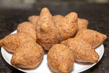 Traditional meat kibbeh (kibe), typical food from the middle east, typical turkish, syrian or arabic food, savory from arabic cuisine on white background with selective focus (kibe)