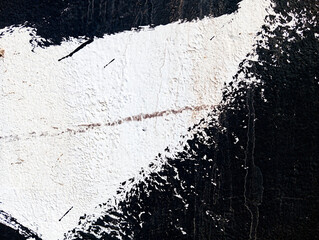 Obraz premium Black paint stains on cement wall. Abstract black paint grunge background. Paint texture with copy space. Stained concrete wallpaper. Brush painted black and white illustration.