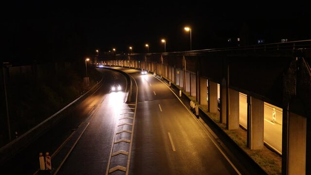Autos kommen auf die Br&uuml;cke zugefahren, bei Dunkelheut und leichtem Regen