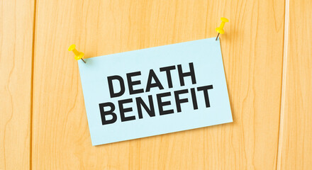 DEATH BENEFIT sign written on sticky note pinned on wooden wall