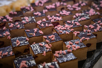A lot of chocolate cakes on a dark background. Selective focus.