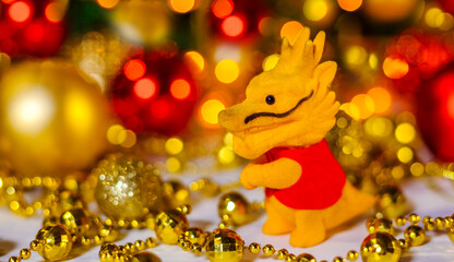 Small Chinese toy dragon on Christmas background. The concept of the holiday is Christmas, New Year. 2024. Space for text. Close-up. Christmas Card