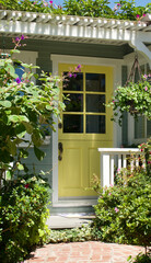 old fashioned beach bungalow with a pastel yellow front door
