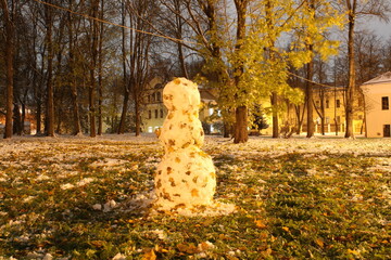 autumn in the park first snow and snowman 