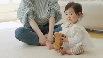 おもちゃで遊ぶ生後9ヶ月の赤ちゃんとママ