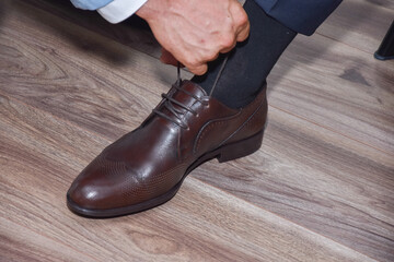 the groom closes his  shoes on the wedding day