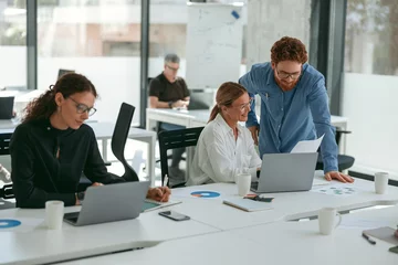 Foto op Plexiglas Business people working with laptops in office on colleagues background. Teamwork concept © Kostiantyn