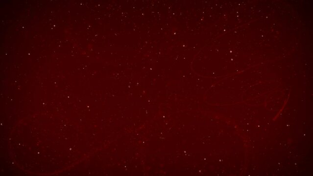 Christmas Glitter Swirl Snow Background 4K Loop features a dark red atmosphere with subtle swirls and particles animating on and off the screen in a loop.
