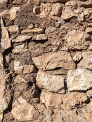 Weathered and rough destroyed  concrete stonewall. Abstract brown rough ancient wall background.