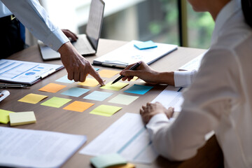 Executives are selecting planning decisions from a group of suggestions written on sticky notes