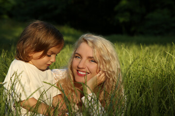 Happy mother with her cute daughter spending time together outdoors