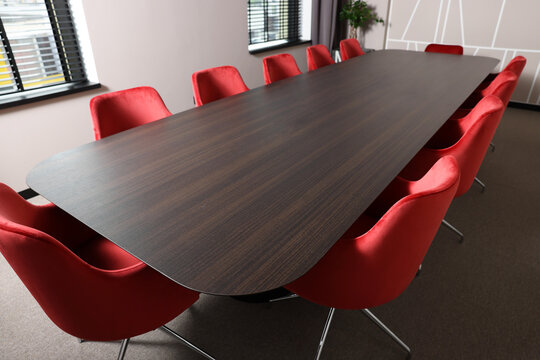 Empty Conference Room With Stylish Red Office Chairs And Large Wooden Table