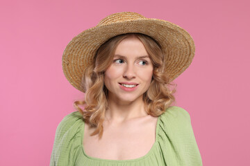 Portrait of beautiful woman with blonde hair in hat on pink background