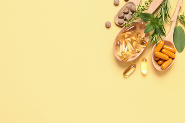 Different pills and herbs on light yellow background, flat lay with space for text. Dietary...
