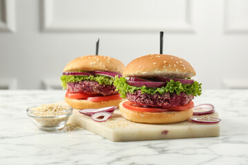 Tasty vegetarian burgers with beet patties on white marble table