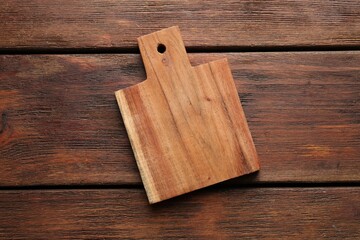 One new cutting board on wooden table, top view