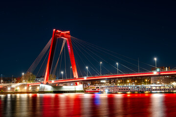 The Willemsbrug Bridge in Rotterdam, Netherlands, illuminated at night with mesmerizing long exposure light effect, creating a stunning visual display.