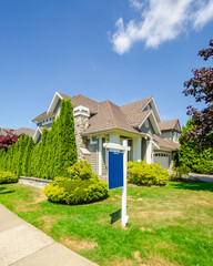 Luxury house with for sale sign at sunny day in Vancouver, Canada.