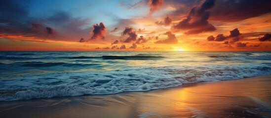 Fototapeta na wymiar As the sun sets over the horizon, casting a golden glow across the serene ocean, the sky is painted with vibrant hues of blue and orange, reflecting beautifully on the water below, creating a