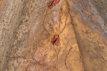 Close up side view of pyramid angle, background texture of cracked concrete with rusty rebar
