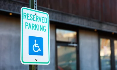 Fototapeten handicap parking sign in blue and white on a paved lot, symbolizing accessibility and inclusivity in urban spaces © Your Hand Please