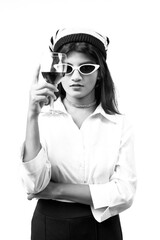 woman holding vine glass and cigar in hand wearing sunglasses and white top 