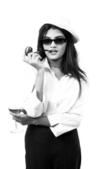 woman holding vine glass and cigar in hand wearing sunglasses and white top 