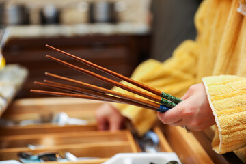 wooden chopsticks resting on a ceramic dish, depicting Asian dining culture and traditional...