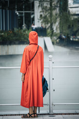 A tourist wearing the mandatory red robe to visit a mosque in Kuala Lumpur.