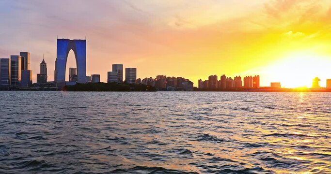 Suzhou skyline and modern buildings scenery at sunset by the lake, Jiangsu Province, China. Beautiful Jinji Lake landscape in Suzhou.