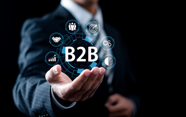 B2B Marketing concept, Businessman holding B2B business marketing technology icons for business action plan strategy and online marketing, Business to business.
