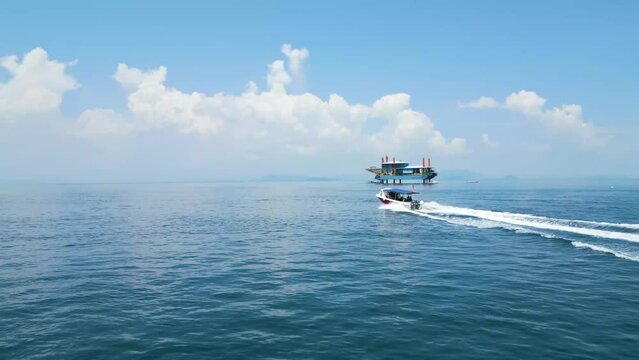 Aerial orbiting shot of a small celebes sea boat heading out to sea with divers