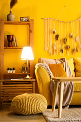 Obraz na płótnie Canvas Interior of stylish living room with cozy yellow sofa and glowing lamp