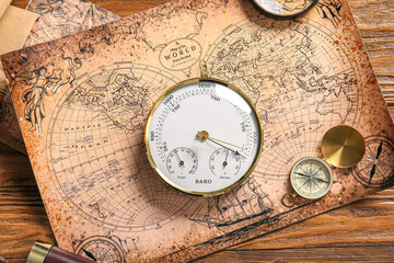 Composition with aneroid barometer and compass on world map. Sailing concept