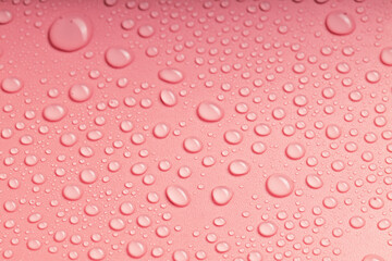 the close-up drops on the pink surface are randomly arranged