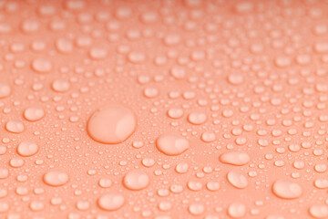 shallow depth of field on a drop of water on an orange surface