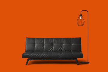 Modern black leather sofa with lamp on orange background