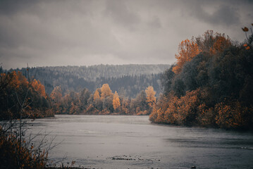 beautiful autumn landscape on the river with trees and cloudy sky - retro vintage effect
