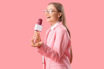 Female journalist with microphone on pink background