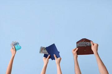Female hands with wallets and money on blue background