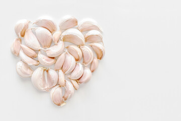 Garlic cloves in a heart shape with copy space on the right. 