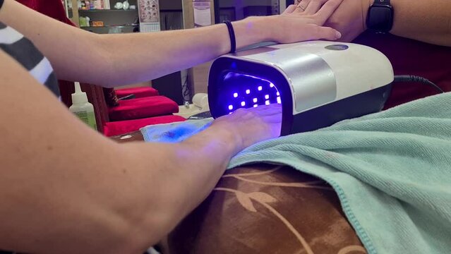 Young woman receiving a gelish nail manicure in Bangkok, Thailand