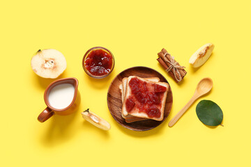 Delicious breakfast with sweet toasts, quince jam and jug of milk on yellow background